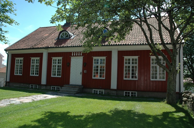 Timmerknutarna är vitmarkerade i kontrast till den röda panelklädda fasaden.