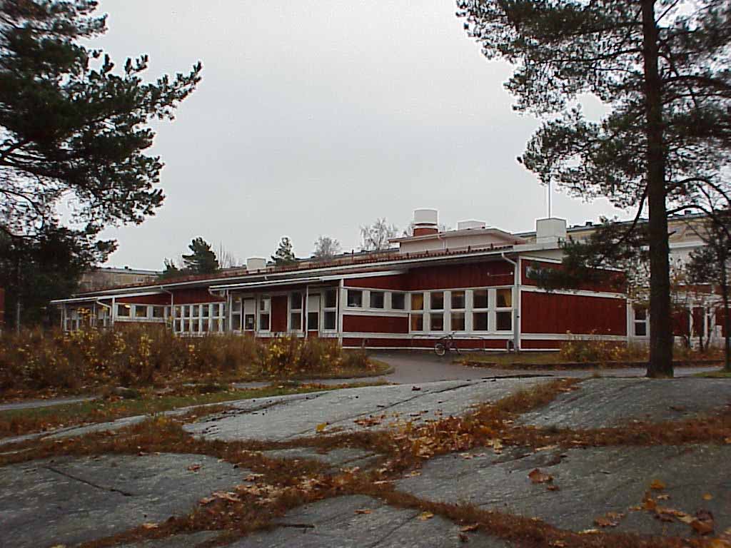 Skolan betraktad från skogsbrynet i väst. 