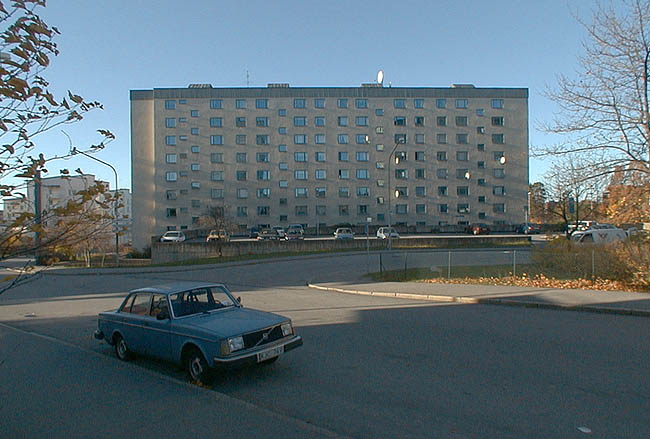 SAK00061_Stockholm, Bredäng, Lindkronan 1, Concordiavägen 1,3 Vita Liljans väg 60-68. 

Skivhusets östra fasad. Fotografiet är taget från Vita Liljans väg. I bildens mitt infarten till Concordiavägen. 