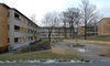Gårdsmiljö med lekplats och höga träd. Till vänster i bilden syns en trappa till cykelrum i källare. 

SAK02061_Stockholm, Skärholmen Idholmen, Idholmsvägen 124-158 från väst