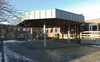 Matsalsbyggnaden, entré med skärmtak. I bakgrunden östra klassrumslängan. 

SAK02020 Stockholm, Skärholmen, Falkholmen 3, Stångholmsbacken 91-95, från sydost (hus 4)