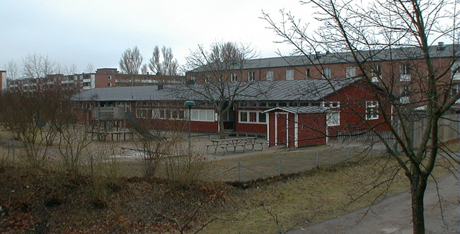 SAK03692. Sthlm, Vårberg, Fjäderholmen 1, Svanholmsvägen 10, 

Byggnadens långsida mot öster, foto från nordöst.
