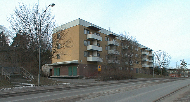 SAK03533 Sthlm, Vårberg, Byholmen 2, Vårholmsbackarna 104-112 (jmn nr) från sydost

Hus 4 med lastkaj och skärmtak på gaveln.

