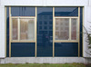 Skärholmen, Måsholmen 25, Oxholmsgränd 2-10.

Fasaden i bottenvåningen består av mörkblåa glasskivor i lister av guldeloxerad aluminium mellan vita betongpelare.

  
