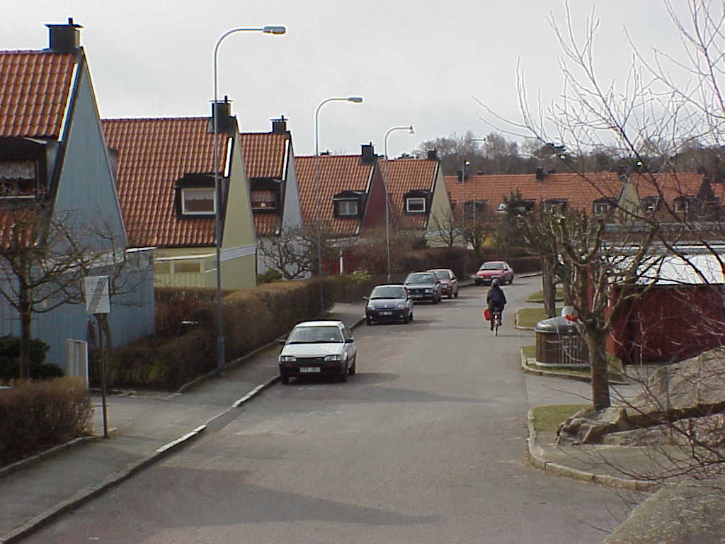 Radhusen ligger med slutna gavlar åt Grässkärsgatan. De branta sadeltaken är ovanliga för sin ålder och takkupan sitter extremt nära gaveln. Garagelängor syns till höger i bild. 