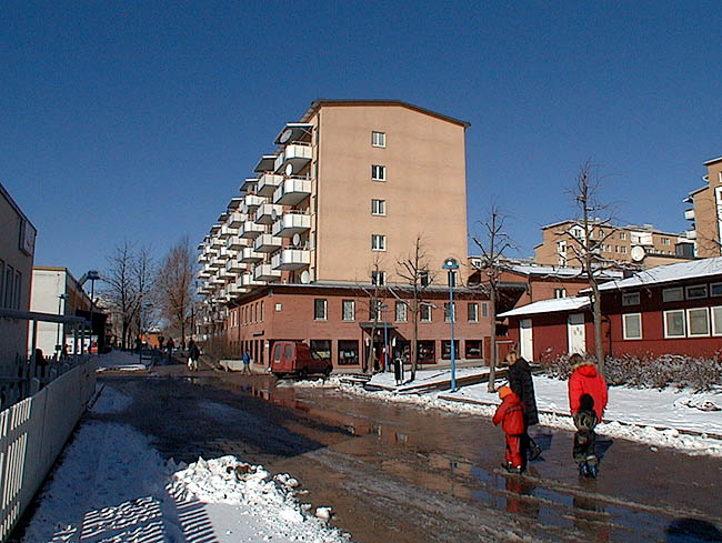 Rinkeby, Hinderstorp 1, Hinderstorpsgränd 4-26

Söder om området löper en gångväg som skiljer husen från Rinkeby centrum. I bildens mitt den östliga delen av det östliga huset, en i början av 1990-talet tillkommen byggnadskropp i två våningar.
