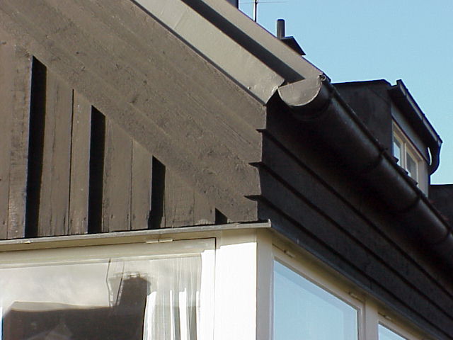Detaljbild tak. Vindskivornas panel består av fyra bräder i fjällpanel som fortsätter på entréfasaden längs takfoten.