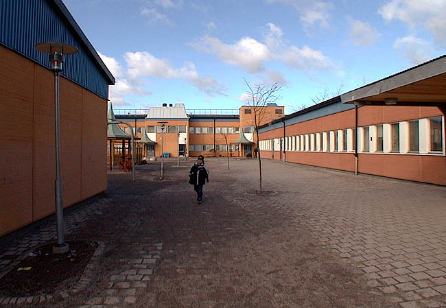 Rinkeby, Stolpkvarnen 2, Bredbyplan 36.

Mellan hus B och hus C bildas en passage in till västra skolgården. I fonden syns hus A.