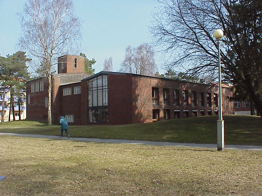 Björkekärrs kyrka med gräsmatta och flanör.