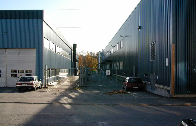 Sätra, Hällsätra 2, Stensätravägen 3.

Till höger i bild byggnadens nordöstliga del, med fasad i mörkblå korrugerad plåt. Mellan Hällsätra 1 och 2 finns en smal asfalterad gård. Bilden är tagen från Stensätravägen i norr.

 

 