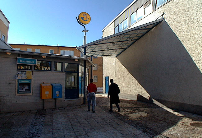 Rinkeby, Kvarnberget 3, Rinkebytorget 8.

Postutbyggnaden har fönster i ramverk av blålackerad aluminium. Posten sammanbinds med huset i Kvarnberget 8 genom ett skärmtak. 

 

 