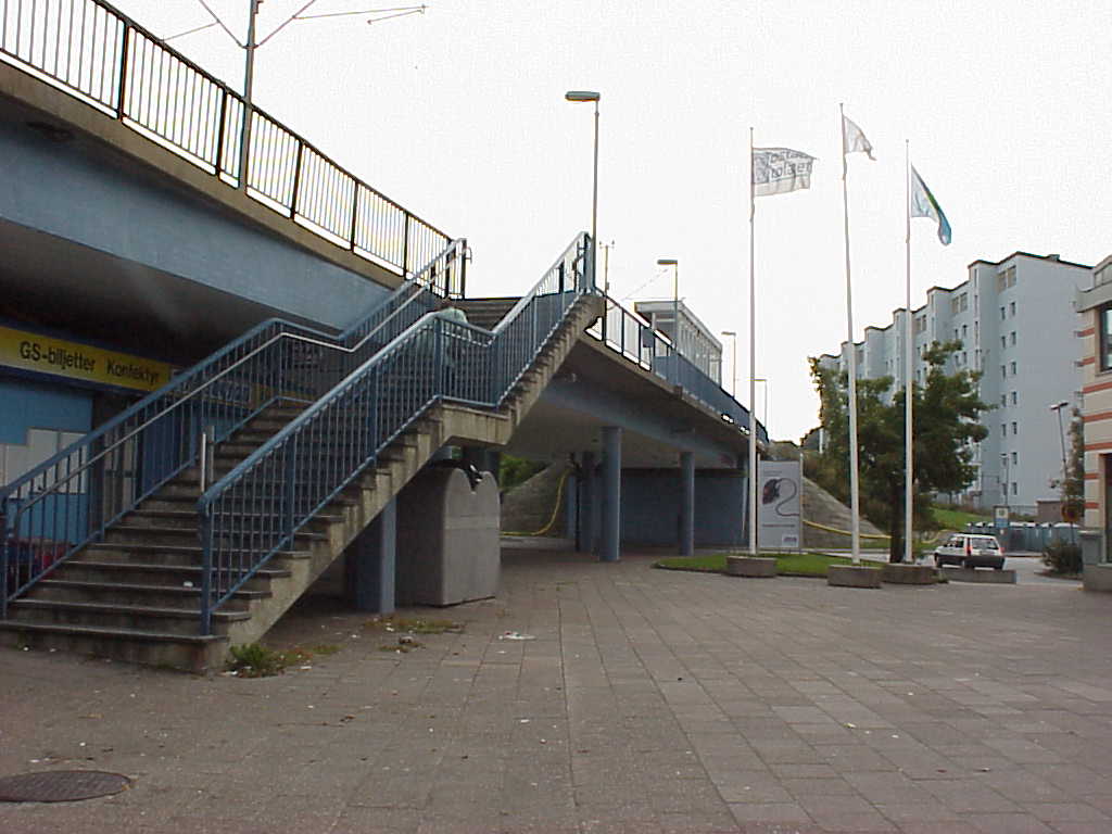 Entrén till torget sker under en spårvägsbro, med hållplats direkt norr om torget.