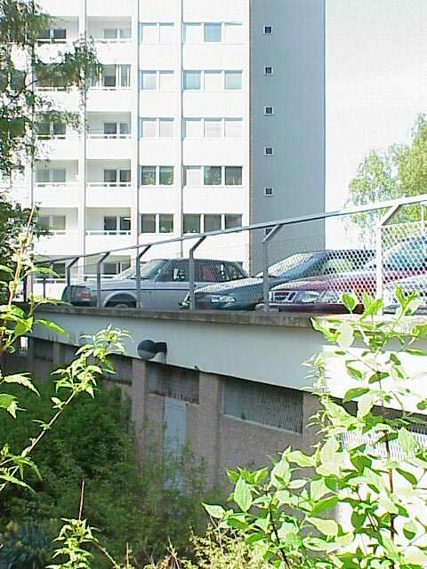 Mellan punkthusen och Kallebäcksvägen finns ett parkeringsdäck.
