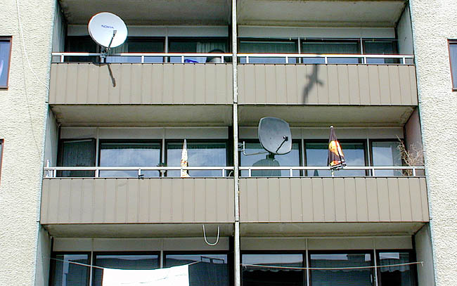 Tensta, Lättinge 1, Lättingebacken 4-46.

Skivhusets balkonger har fronter av brun korrugerad aluminiumplåt.
 