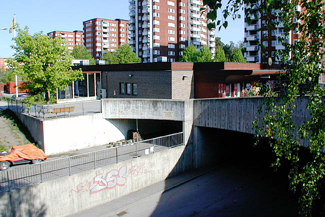 Akalla, Mariehamn 1, Mariehamnsgatan 9-13.

Butiksbyggnaden har en källarvåning som inrymmer garage. Infart sker från den överdäckade bussgatan Sveaborgsgatan, som man på bilden ser löpa ut under Akalla torg.


 