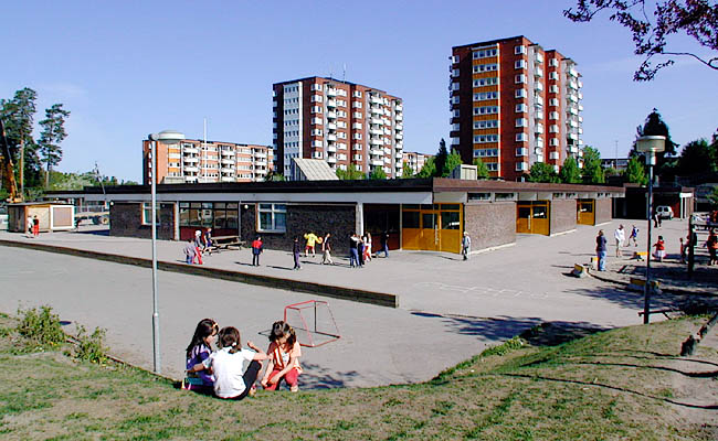 Akalla, Mariehamn 3, Mariehamnsgatan 5, Foto fr SO.

Vy över den asfalterade skolgården från sydost. Varje klassrum har i princip en egen entré. I bakgrunden punkthusen vid Sibeliusgången.