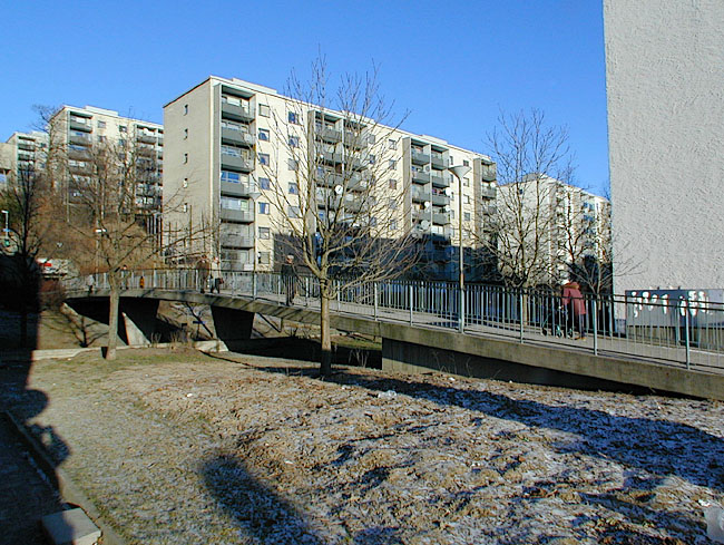 Skärholmen, Harholmen 1,3 del av.

Bron till hissanläggningen löper över Äspholmsvägen, foto från sydväst.
 