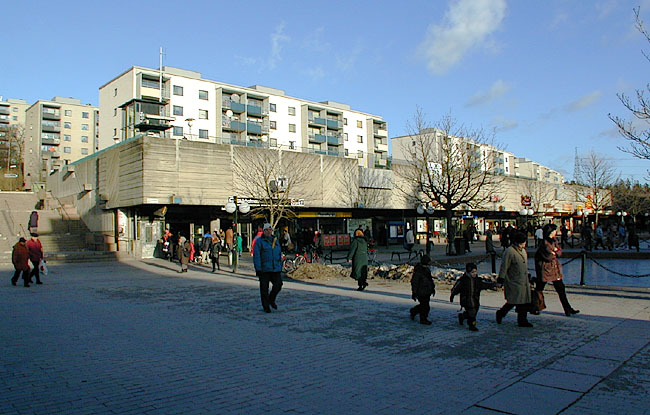 Skärholmen, Måsholmen 12, del av, Ekholmsvägen.

Butiksstråket mot NO. Tunnelbaneuppgången och butikerna utmed Skärholmstorget.