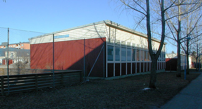 Skolbarackerna med fönsterband mot söder. 

SAK07072 Sthlm, Hjulsta, Hyllinge 1, Hjulstastråket 13, från väst





