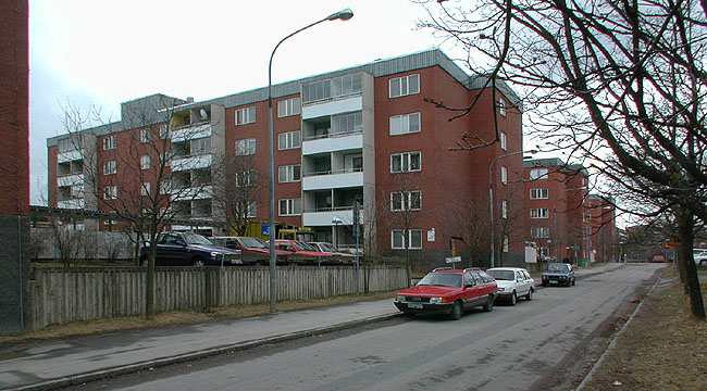 Gårdarnas norra del utgörs av parkeringsplatser. 

SAK07133 Sthlm, Tensta, Stranninge 1, Elinborgsbacke 3-9 (udda nr) från ost
