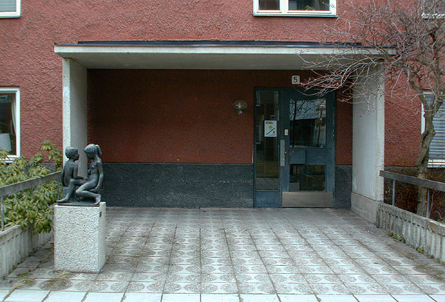 Gårdarnas entrépartier är fint utformade med breda skärmtak, mönstrade betongplattor och en liten skulptur.

SAK07135 Sthlm, Tensta, Stranninge 1, Elinborgsbacke 3-9 (udda nr) från sydost