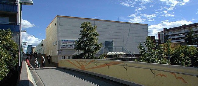 Edvard Griegsgången förs på en gångbro över Oslogatan.

SAK10208 Sthlm, Husby, Husby centrum från N
