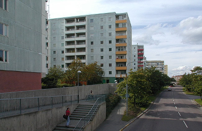 Höghusen är placerade med gavlarna mot Oslogatan. Trapporna leder ner till busshållplatser i gatunivå. 

SAK10357 Sthlm, Husby, Bergen 1, Ålesund 1, från SO


