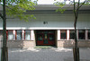 Skolan huvudentré mot Edvard Griegsgången. 
SAK10025 Sthlm, Husby, Nidaros 3, Edvard Grieg gången 26, från SV