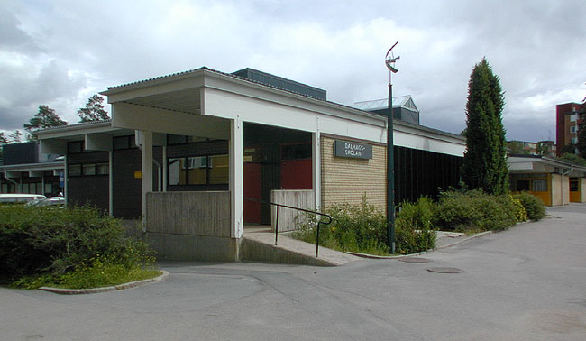 De mörka fönsterpartierna till höger om lastkajen vetter in mot skolans matsal. 
SAK10063 Sthlm, Husby, Lofoten 4, Lofotengatan 32-34, från SV