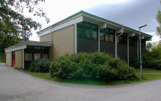 Gymnastikbyggnaden, som är sammanbyggd med resten av skollokalerna, består av en högdel, gymnastiksal, och lågdel, omklädningsrum. 
SAK10068 Sthlm, Husby, Lofoten 4, Lofotengatan 32-34, från N
