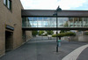 Gångbro över Ärvingegången som förbinder skolan och Kista träff. Till vänster entrén till centrumgården. 
SAK12071 Sthlm, Kista, Ålborg 2, Köpenhamnsgatan 11, från SO

