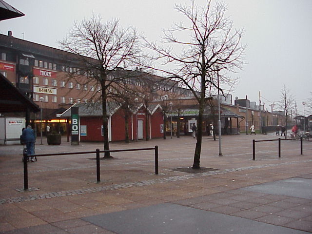 Södra butikshuset med torgytan i förgrunden med de röda fiskebodarna, som vänder avigsidan till besökarna. Till höger skymtar spårvagnsstationen.