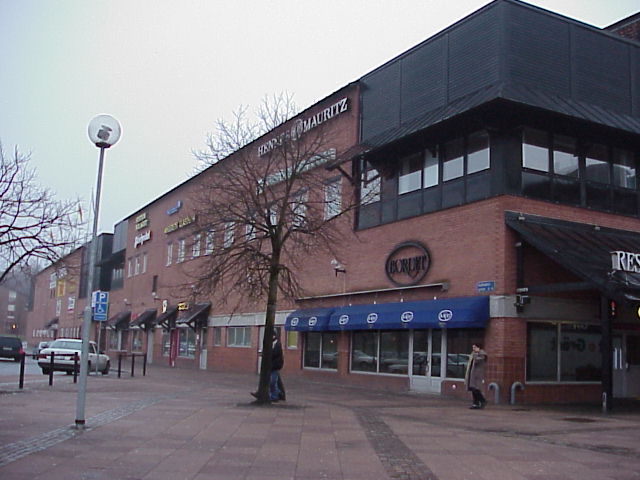 Den norra butiksbyggnaden har ett stort hörnparti med den svarta plåtpanel som bitvis täcker fasaderna.