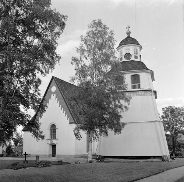 Arbrå kyrka och klockstapeln från sydväst. 
