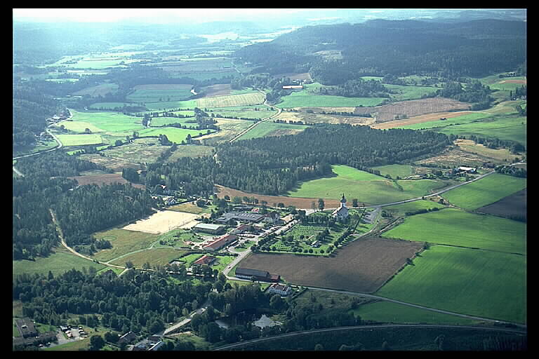 Björketorps kyrka med omgivningar. Kyrkan i bilden högra del. Flygbild.