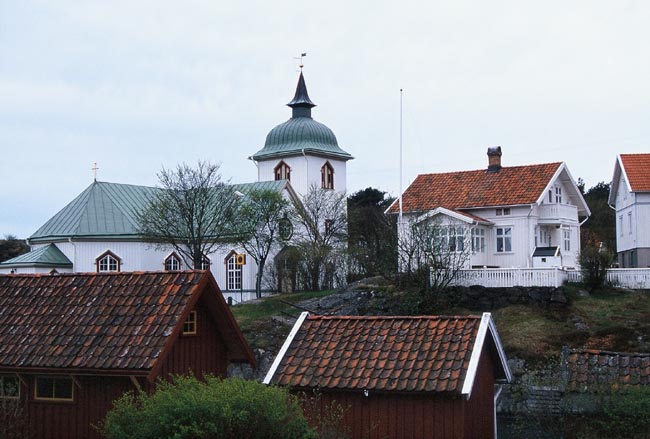 Kyrkan omgiven av bebyggelse på alla sidor.