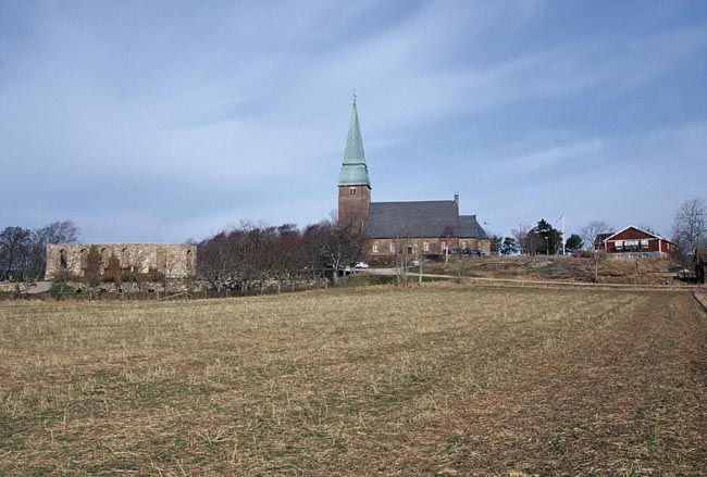 Kyrkplatsen från lite håll. Ruinen till vänster, kyrkan i mitten och församlingshemmet till höger. 