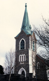 Kyrkan har västtorn med kopparklädd tornhuv. 