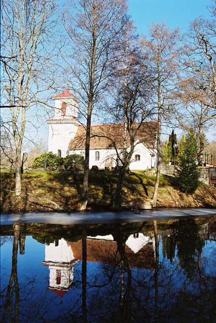 Kilanda kyrkas kyrkogård inramas på flera sidor av Kilandaån. Kyrkan sedd från söder. 