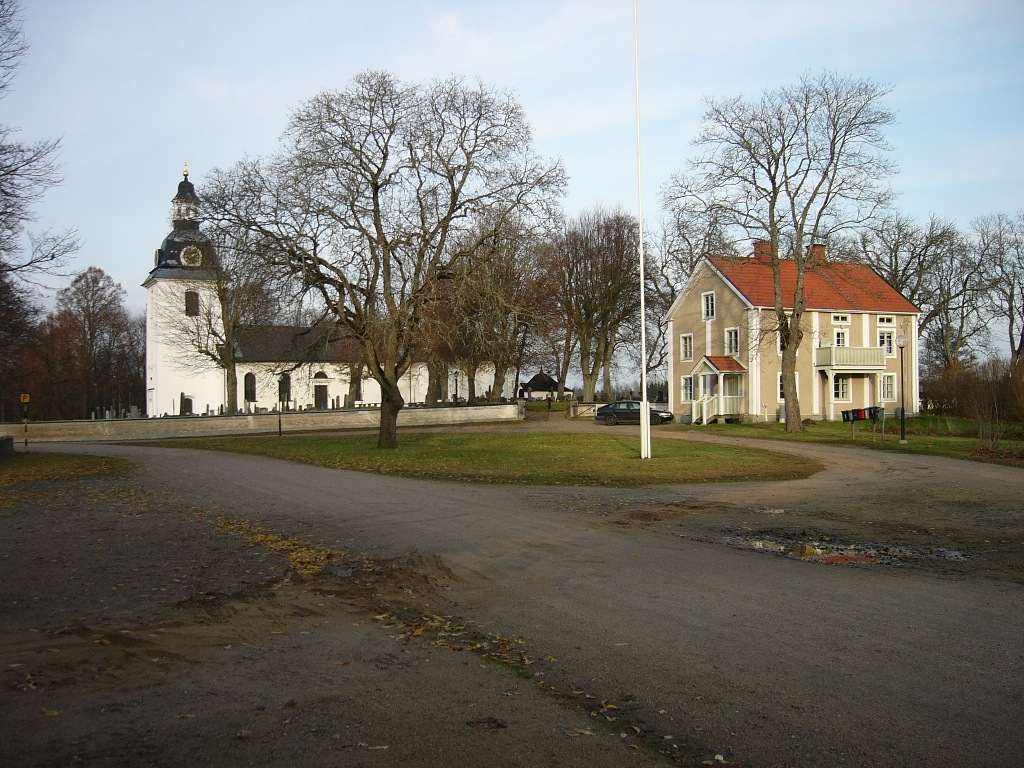 Skedevi kyrka och klockarebostaden från söder.