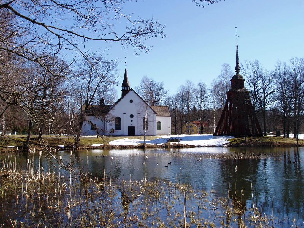 Gusums kyrka och klockstapel från väster.