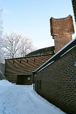 Församlingsdelens södra fasad på Aspenkyrkan samt kyrkorummet och huvudentrén rakt fram, från Ö.