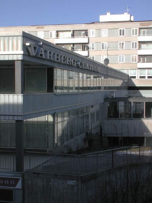 Sthlm, Vårberg, Vårholmen 4 Fjärdholmsgränd 4-38 (jmn nr) Vårbergsplan 3-11(udda nr) från sydsydost . Vårbergs centrum har eleganta fönsterband.
