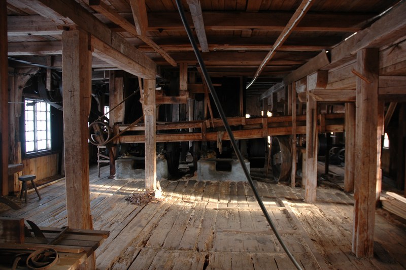 Vretens sågverk, såghusets bottenvåning, i bakgrunden ramsågarnas stativ och transportbanan för spån till maskinhuset. I förgrunden det utrymme som fungerade som snickeri. 