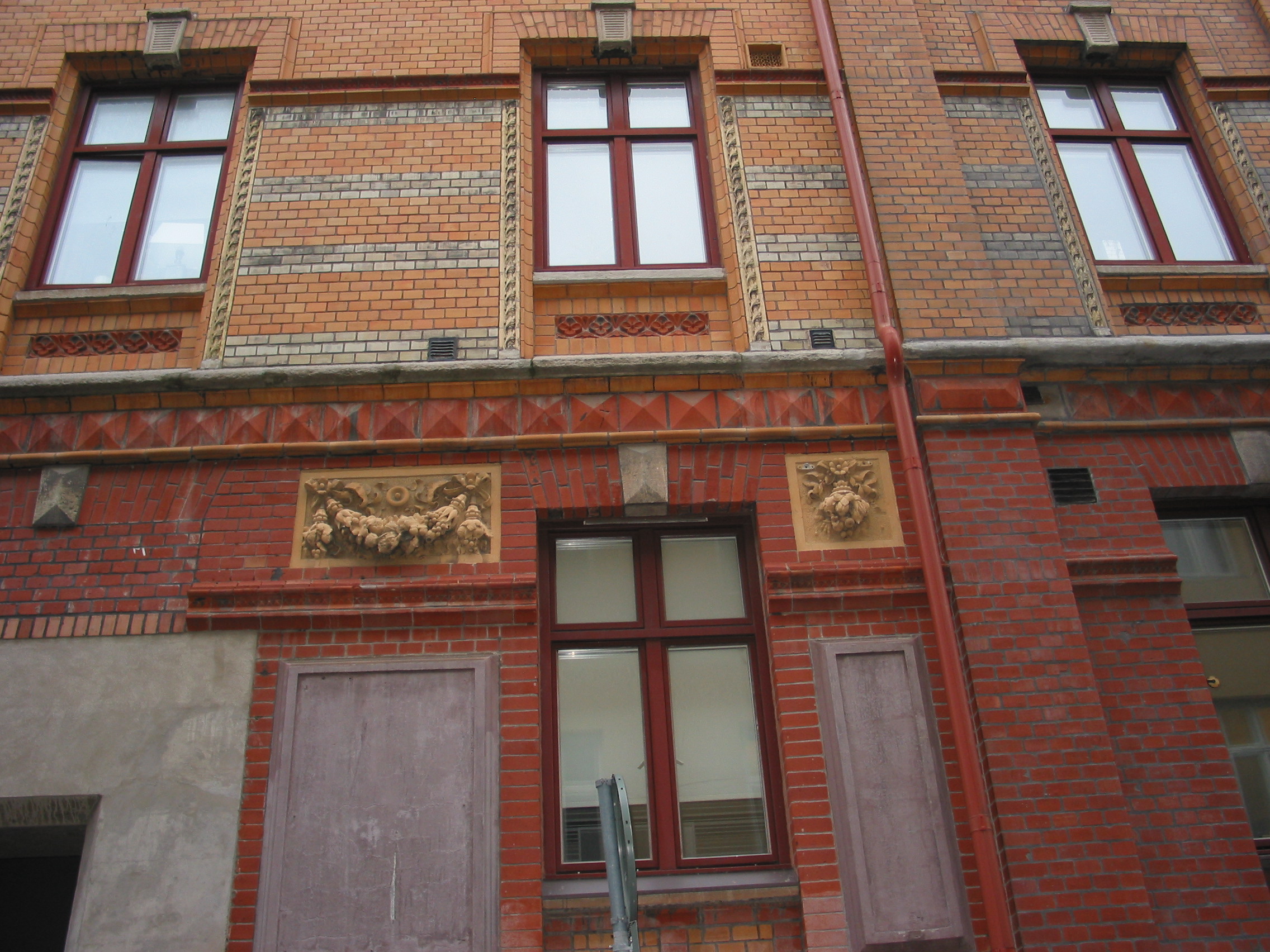 Detalj av Adlers fasad för frukthandlare Mühlenbocks byggnad med magasin och kontor (uppförd 1885). Festongerna med fruktklasar betonar den ursprungliga verksamheten. Handelstidningen tog över hela kvarteret i början av 1900-talet.
