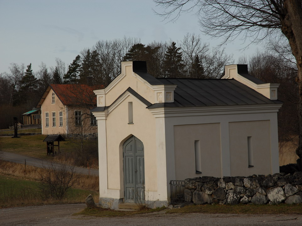 Överenhörna kyrka, tegelmurad byggnad i kyrkogårdens sydvästra hörn