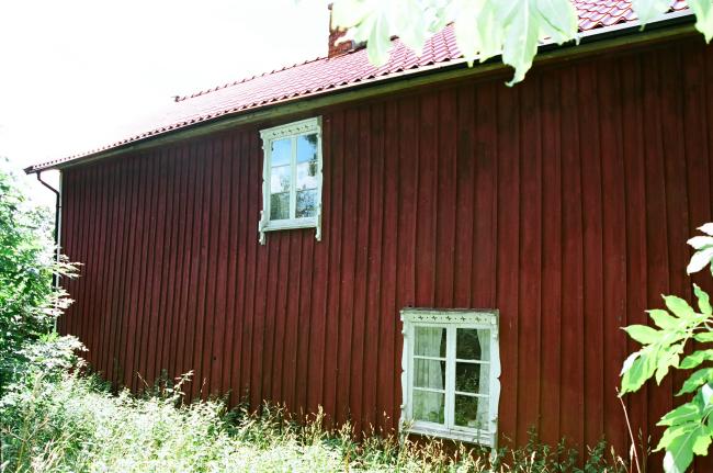 På husets baksida har man lagt på tegelimiterande plåt för att skydda stugan mot väder och vind. Bilden tagen från nordöst.