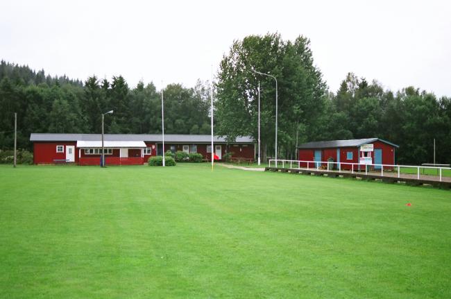 I bakgrunden ser man klubbhuset och till höger står Förrådet. Bilden tagen från nordöst.