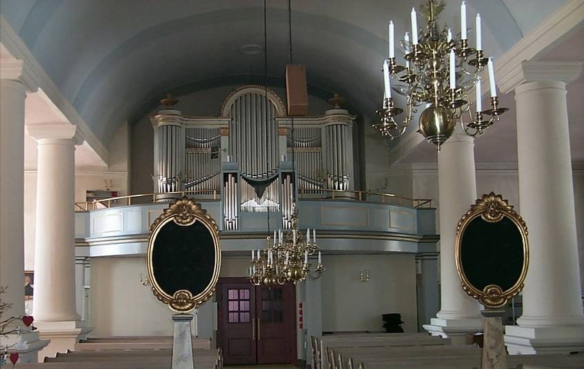 Interiör, kyrkorummet mot ingången och orgelläktaren. 

Vid kyrkans utvidgning 1791-92 byggdes fyra kraftiga pelare, vilka bär upp mittskeppet och är mycket karaktärsskapande. Siffertavlorna i förgrunden är från 1790-talets nyinredning. Orgelverket från 1832 mekaniserades 1937 samtidigt som orgelläktaren utvidgades för att kunna rymma kör - Digitalfoto Svensk Klimatstyrning AB