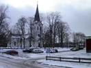 Värnamo kyrka sedd från nordväst. Kyrkan ligger idag omgiven av äldre träd som ger
kyrktomten en parkkaraktär. Bakom skymtar Kyrktorget och det sentida stadshuset.